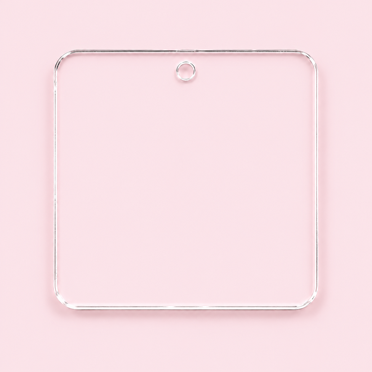 Clear rounded square acrylic blank with a top center hole, shown on a blush pink background.