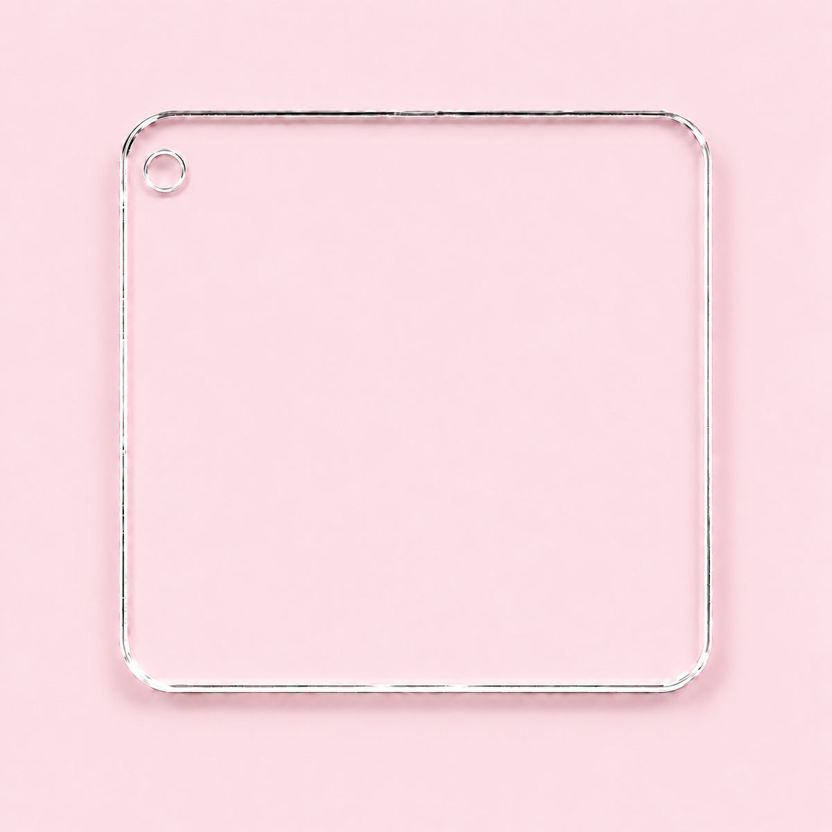 Clear rounded square acrylic blank with an upper left corner hole, shown on a blush pink background.