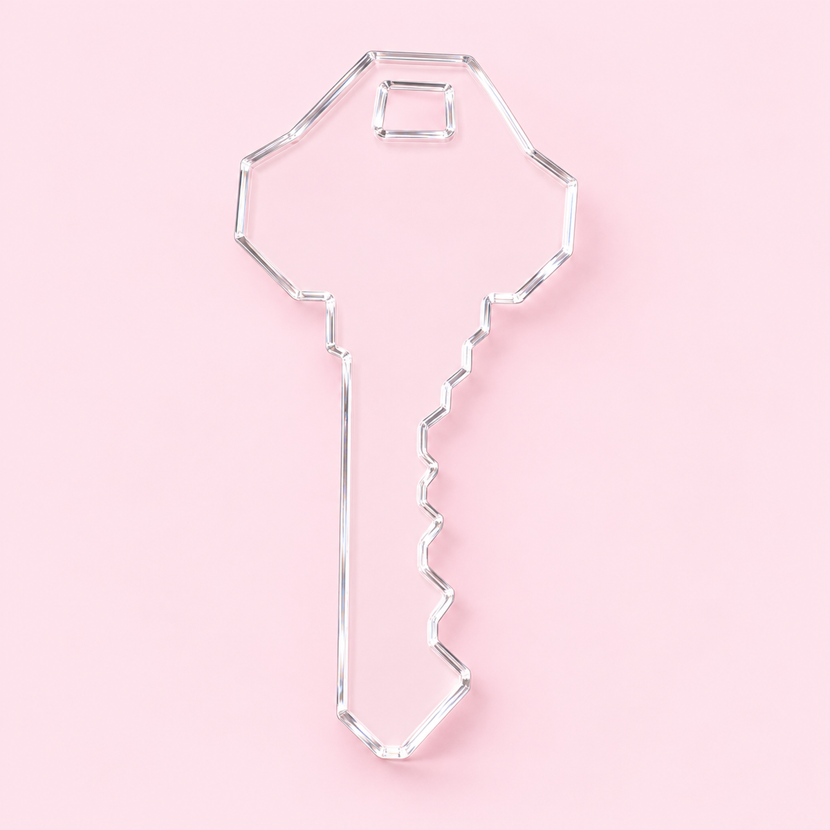 Clear key-shaped acrylic blank with a rectangular cutout at the top on a blush pink background.
